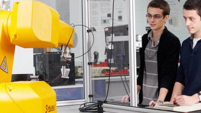 Two students using a robotic arm