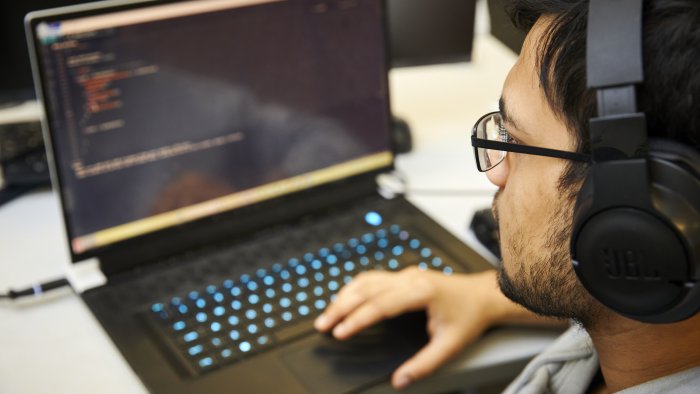 Student wearing headphones while using a laptop