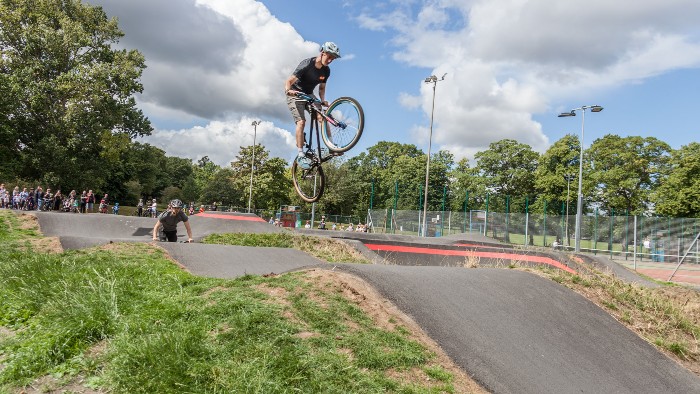 Two people on bikes using a pump track