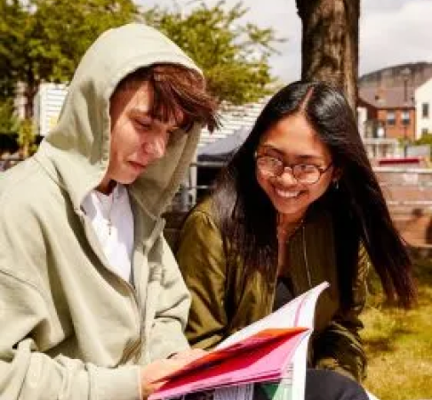 Students reading book outside