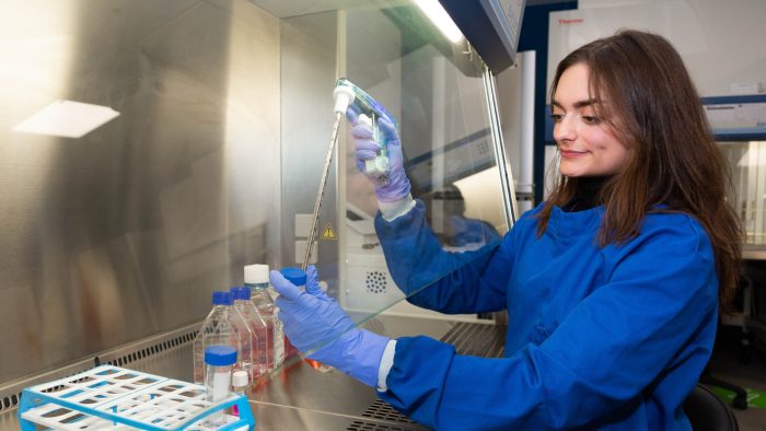 A student wearing PPE running a test in the mass spectrometry suite