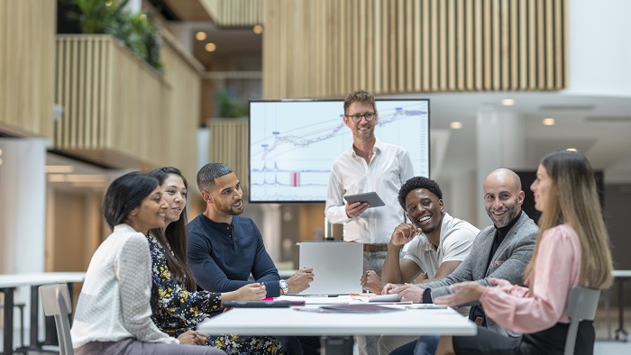 Seven postgraduate students meeting around a table at University