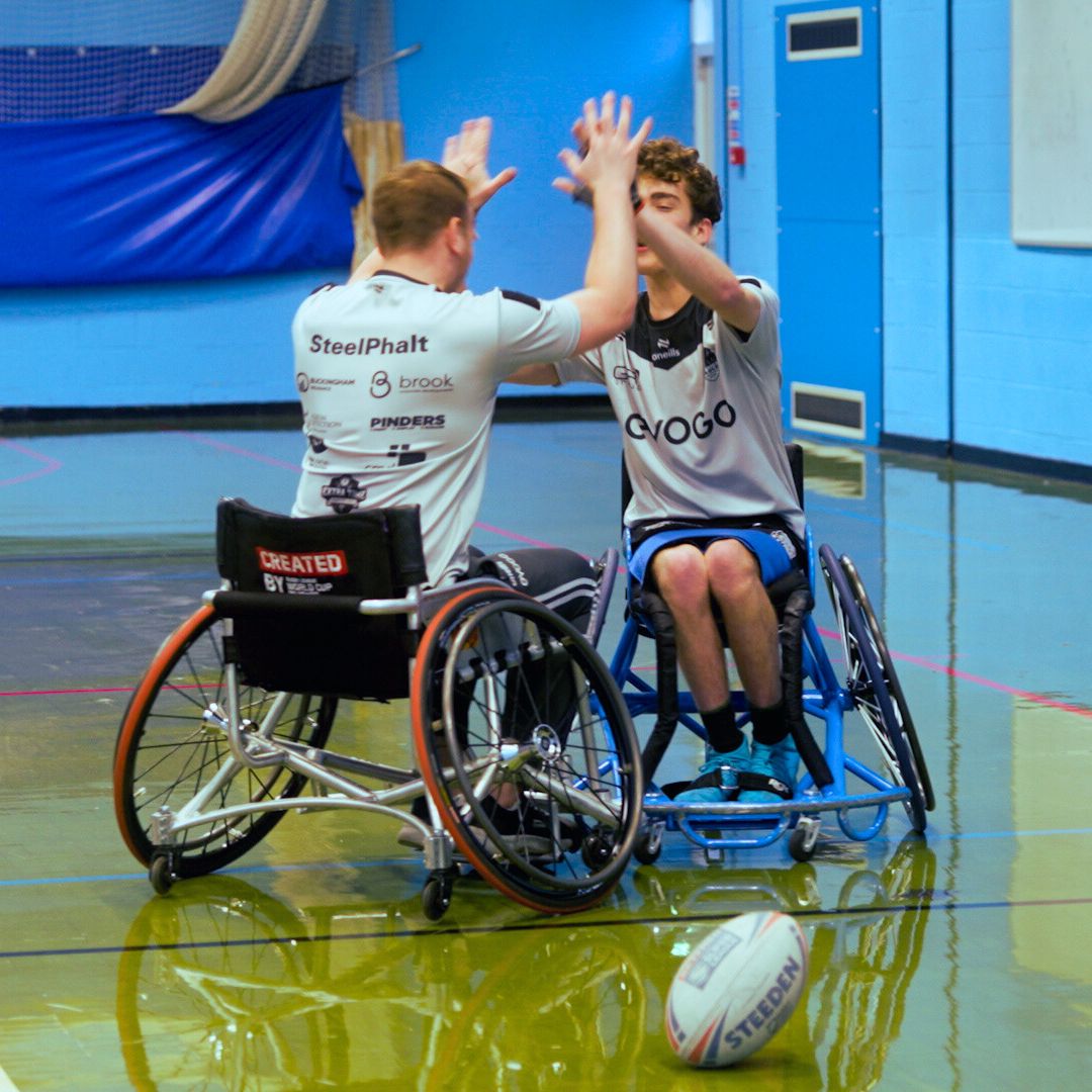 Two people playing wheelchair basket ball 