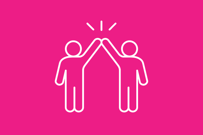 Two people high five on a pink background