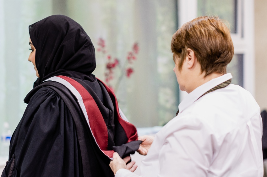 Graduate getting gowned on graduation day 