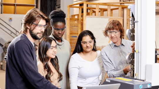 Engineering students gathering around equipment