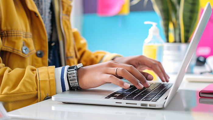 A female student typing on a laptop.