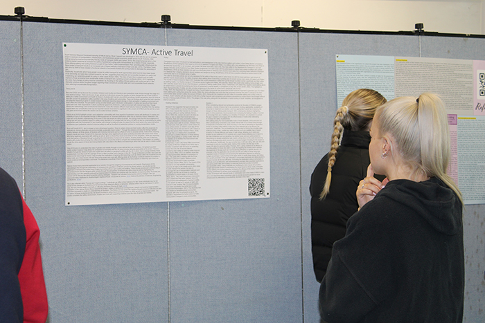 A criminology student reading and thinking about some of the research displayed on a poster design.