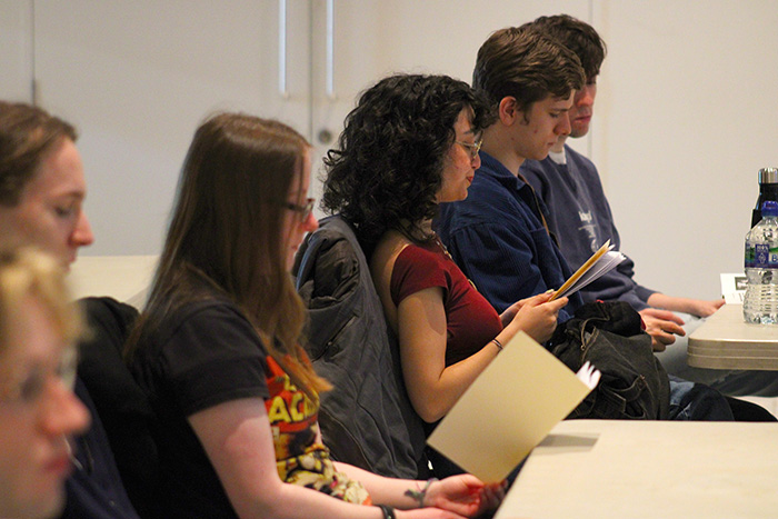 Students attending the collaborative project event, reading a zine that was created to complement the event.