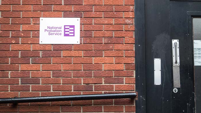 A National Probation Service sign on the brick wall of a building