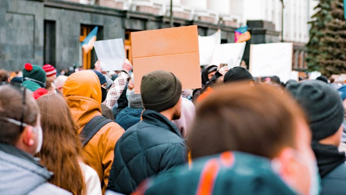 A crowd of people holding up signs at a strike or demonstration