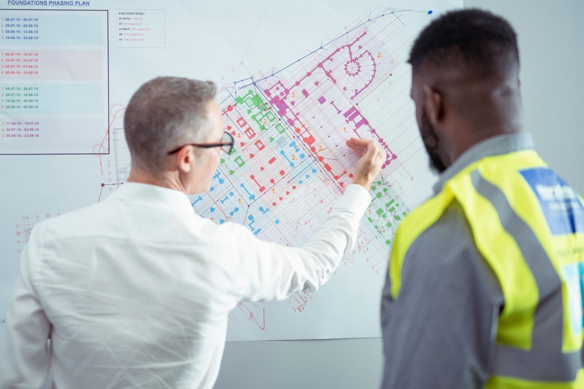 A lecturer and a student reviewing building plans. 