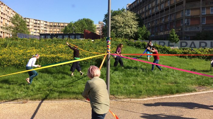 People moving round a maypole with ribbon
