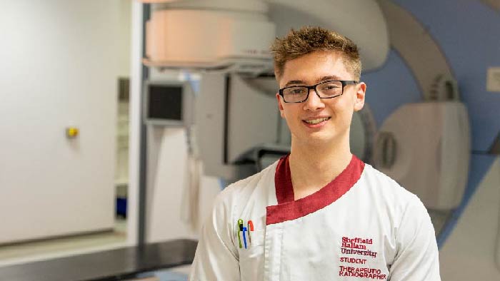 Radiotherapy student infront of a linear accelerator