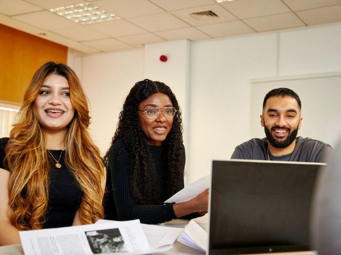 three students smiling in a class