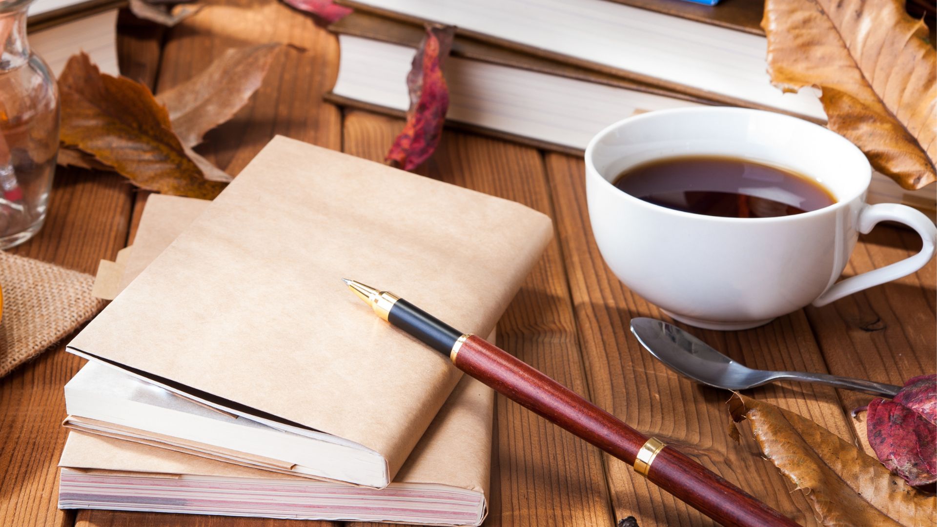 Books and study materials and a drink with autumn leaves