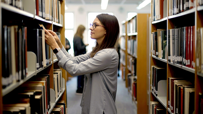 A woman looking at books in a library.